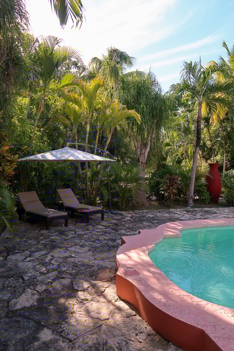 Lounge chairs by the pool at Hacienda Sacnicte. Relaxing by the pool at this hacienda is one of the best things to do in Izamal, Yucatan.