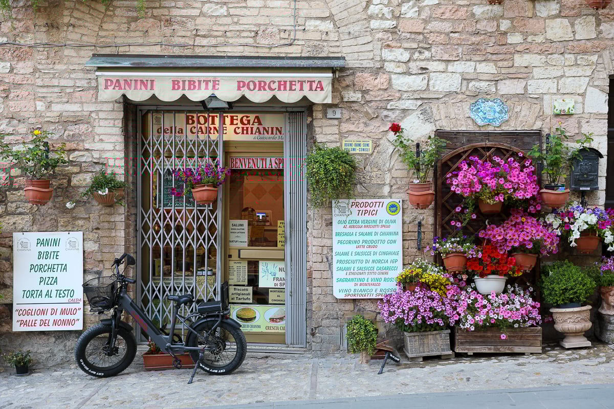 Sandwich shop decorated with pretty flowers outdoors in Spello, Umbria, Italy