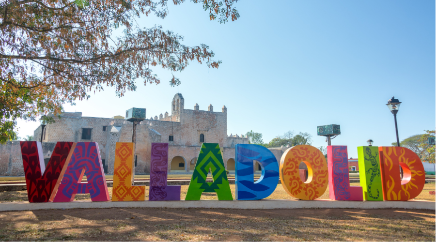 A colorful letter sign spelling out "Valladolid" in front of an old convent. Exploring this convent is one of the best things to do in Valladolid, Yucatan, Mexico!
